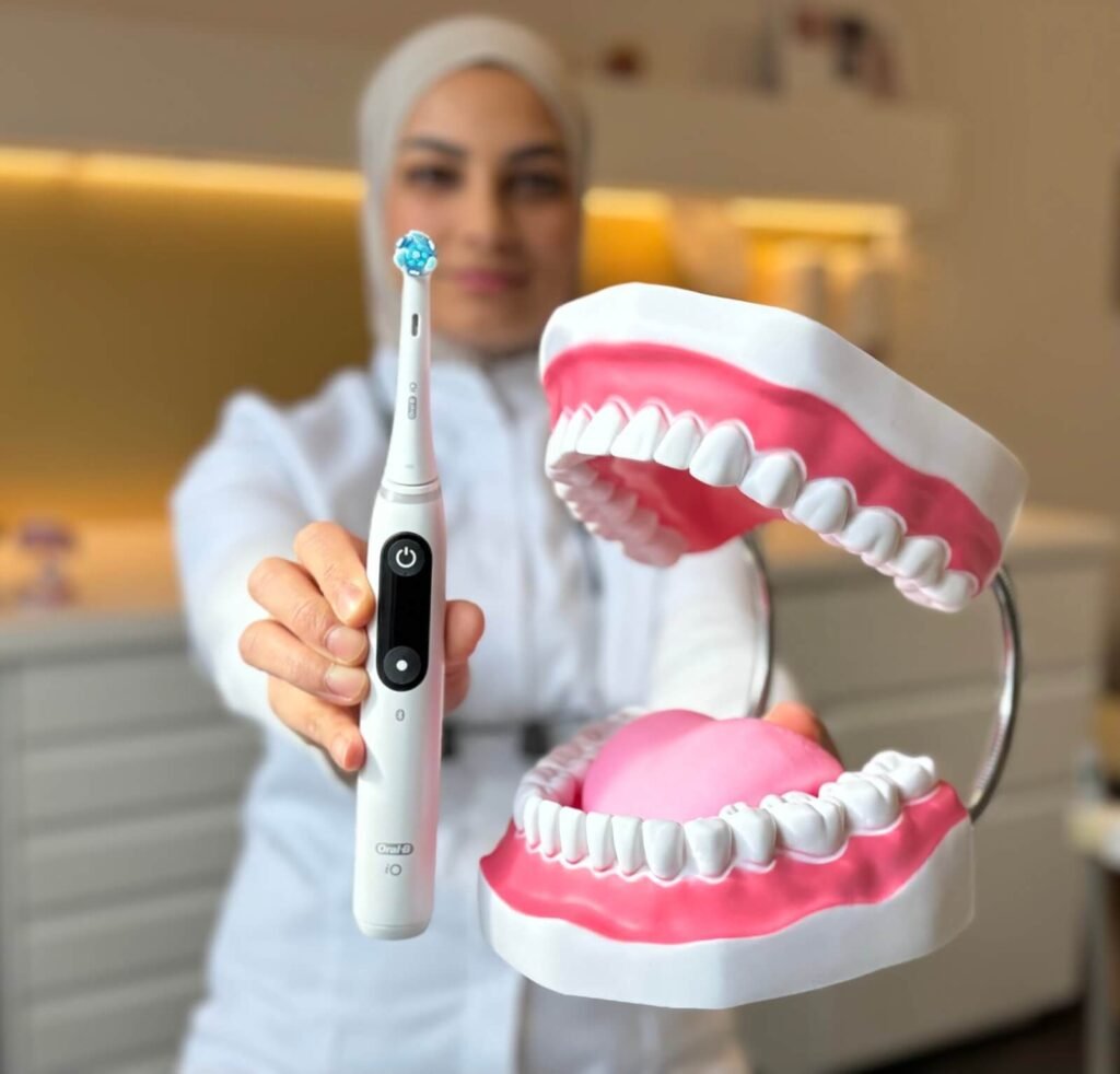 Narges houdt een elektrische tandenborstel en een groot kaakmodel vast voor poetsuitleg.